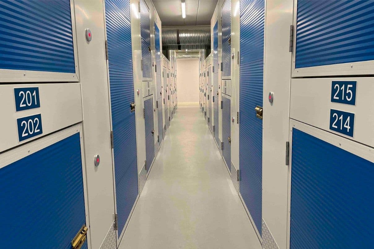Hallway of numbered storage units with blue doors at CityBox Midtown